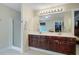 Bathroom boasts dual sinks, dark wood cabinets, and a glass shower, for a luxurious feel at 9524 Markley Blvd, Summerville, SC 29485