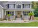 Inviting front porch featuring classic columns and decorative wreaths, creating a warm welcome at 9524 Markley Blvd, Summerville, SC 29485