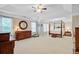 Sunlit primary bedroom with a four-poster bed, side tables and lamps, dresser and a round mirror at 9524 Markley Blvd, Summerville, SC 29485