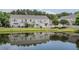 Exterior view of townhomes with a scenic pond, reflecting the buildings and surrounded by green space at 1003 Washitonia Way # A, Charleston, SC 29492