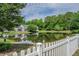 Enjoy the tranquil pond view from this home, enhanced by the classic white picket fence and mature trees at 1003 Washitonia Way # A, Charleston, SC 29492