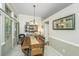 Dining area features rustic wood table, chandelier lighting, and views into other living spaces at 104 S Ansel Xing, Goose Creek, SC 29445