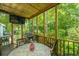 Relaxing screened porch with a television, dining table, and views of the lush greenery at 104 S Ansel Xing, Goose Creek, SC 29445