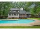 Large in-ground swimming pool surrounded by a concrete patio, set against a backdrop of a charming home and lush greenery at 105 Londonderry Rd, Goose Creek, SC 29445