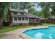 View of the backyard inground pool with home and trees in the background at 105 Londonderry Rd, Goose Creek, SC 29445