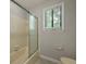 Bathroom with window, shower with glass doors, and cream and gray color scheme at 105 Londonderry Rd, Goose Creek, SC 29445