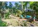 Landscaped backyard with a wooden bench, lounge set, privacy fence, and lush trees create a tranquil space at 1081 Groves Manor Ct, Mount Pleasant, SC 29464
