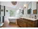 Bright bathroom with a soaking tub under a window and double vanity sinks with a view of the outside at 1081 Groves Manor Ct, Mount Pleasant, SC 29464