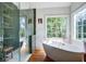Bathroom featuring a soaking tub under a window and a glass-enclosed shower with green tiling and view of outside at 1081 Groves Manor Ct, Mount Pleasant, SC 29464
