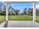 Covered porch view of an expansive backyard with lush green lawn and a serene waterfront at 1095 Saltwater Cir, Johns Island, SC 29455