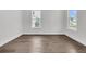 Bright, empty bedroom with hardwood floors, two windows, and white trim at 1095 Saltwater Cir, Johns Island, SC 29455