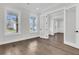 Open bedroom with hardwood floors, white trim, and natural light streaming through large windows at 1095 Saltwater Cir, Johns Island, SC 29455