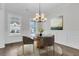 Elegant dining room with a round table, modern chandelier, and views from the windows at 1095 Saltwater Cir, Johns Island, SC 29455
