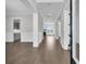 Inviting hallway featuring hardwood floors, white trim, and a view to the living room with fireplace at 1095 Saltwater Cir, Johns Island, SC 29455