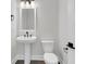 Charming powder room featuring a pedestal sink and toilet with modern fixtures and neutral paint at 1095 Saltwater Cir, Johns Island, SC 29455