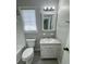 Well-lit bathroom with a white vanity, toilet, and a bright window at 1102 Hampton Ct, Summerville, SC 29486