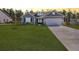 Charming single-story home with a well-manicured lawn, attached garage, and inviting curb appeal at 1144 Wading Point Blvd, Huger, SC 29450