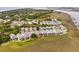 Stunning aerial view of a waterfront community featuring colorful homes and marshland, with ocean views in the distance at 116 W 2Nd St, Folly Beach, SC 29439