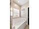 Bright bathroom showcasing a tiled white jacuzzi tub near a black door at 116 W 2Nd St, Folly Beach, SC 29439