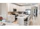 Bright, open-concept kitchen with white cabinets, an island with seating, and stainless steel appliances at 116 W 2Nd St, Folly Beach, SC 29439