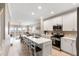 Bright, open-concept kitchen with white cabinets, an island with seating, and stainless steel appliances at 116 W 2Nd St, Folly Beach, SC 29439