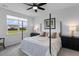 Bright bedroom features a four-poster bed, ceiling fan, and view to the outside at 1173 Wading Point Blvd, Huger, SC 29450