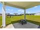 Covered patio has chairs and a table that looks out onto a large green yard at 1173 Wading Point Blvd, Huger, SC 29450