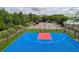 Aerial view of a blue basketball court with red free throw lane surrounded by trees and manicured bushes at 122 Foxglove Ave, Summerville, SC 29483