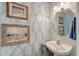 Charming powder room with pedestal sink, decorative wallpaper, and coastal-themed decor at 122 Foxglove Ave, Summerville, SC 29483