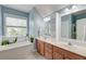 Double vanity bathroom with abundant natural light, a soaking tub, and stylish fixtures at 122 Foxglove Ave, Summerville, SC 29483