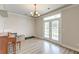 Light-filled dining room with wood-look floors, chandelier, and French doors to the backyard at 122 Foxglove Ave, Summerville, SC 29483