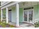 Inviting covered front porch with a porch swing, white columns, and double glass doors at 122 Foxglove Ave, Summerville, SC 29483