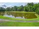 A serene pond surrounded by lush greenery and a walking path on a sunny day at 122 Foxglove Ave, Summerville, SC 29483