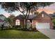 Traditional brick home with a well-manicured lawn, mature trees, and an attached two-car garage at 1232 Palmetto Peninsula Dr, Mount Pleasant, SC 29464