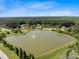 Scenic aerial view of community pond with fountain, lush trees, and houses at 1327 Wood Sorrel Dr, Moncks Corner, SC 29461