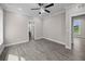 Open bedroom featuring gray wood floors, white trim, and a ceiling fan at 1327 Wood Sorrel Dr, Moncks Corner, SC 29461