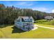 Aerial view of a beautiful two-story blue home nestled among the trees and a manicured lawn at 1327 Wood Sorrel Dr, Moncks Corner, SC 29461
