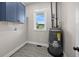 Functional laundry room with blue cabinetry, a large window, and modern water heater at 1327 Wood Sorrel Dr, Moncks Corner, SC 29461