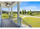 Inviting porch with black railings offers a scenic view of the landscaped yard and pond at 1327 Wood Sorrel Dr, Moncks Corner, SC 29461