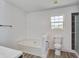Bright bathroom with a soaking tub, window, black fixtures, and wood-look floors at 137 Ashton Dr, Goose Creek, SC 29445