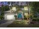 Inviting two-story home with a light gray exterior, a blue front door, and warm interior lighting at dusk at 137 Ashton Dr, Goose Creek, SC 29445