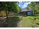 Spacious backyard with mature trees, garden beds, and a charming blue home at 1414 E Crossing Ln, Mount Pleasant, SC 29466