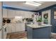 Stylish kitchen featuring a central island, stainless appliances, white cabinets, blue accent walls, and eat-in breakfast area at 1414 E Crossing Ln, Mount Pleasant, SC 29466