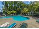 Sparkling community pool surrounded by lounge chairs, lush trees, and mature landscaping at 149 Darcy Ave, Goose Creek, SC 29445