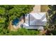 Aerial view of a modern home with a sleek metal roof, a refreshing private pool, and lush landscaping at 1510 Old Rosebud Trl, Awendaw, SC 29429