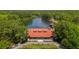 Stunning aerial view of a venue with a red roof, surrounded by lush greenery and a tranquil pond with a pier at 1510 Old Rosebud Trl, Awendaw, SC 29429
