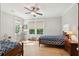 Cozy bedroom featuring hardwood floors, large windows, a ceiling fan, and stylish twin beds at 1510 Old Rosebud Trl, Awendaw, SC 29429