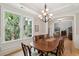 Bright dining room with large window offering outdoor views, chandelier, and wood table at 1510 Old Rosebud Trl, Awendaw, SC 29429