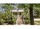 Beautiful two-story home with a covered porch, well-manicured landscaping, and a grand staircase entrance at 1510 Old Rosebud Trl, Awendaw, SC 29429