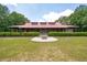 Beautiful wood building with a striking red roof and dormer windows, complemented by a circular fire pit area and manicured lawn at 1510 Old Rosebud Trl, Awendaw, SC 29429